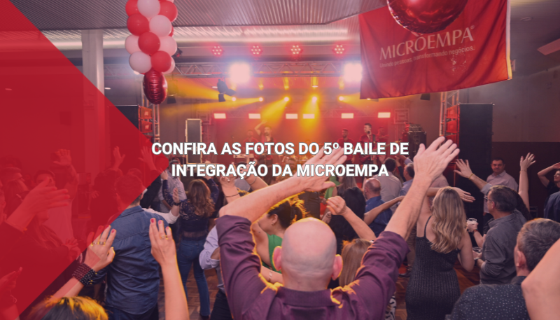 Pessoas dançam com os braços levantados no 5º Baile de Integração da Microempa