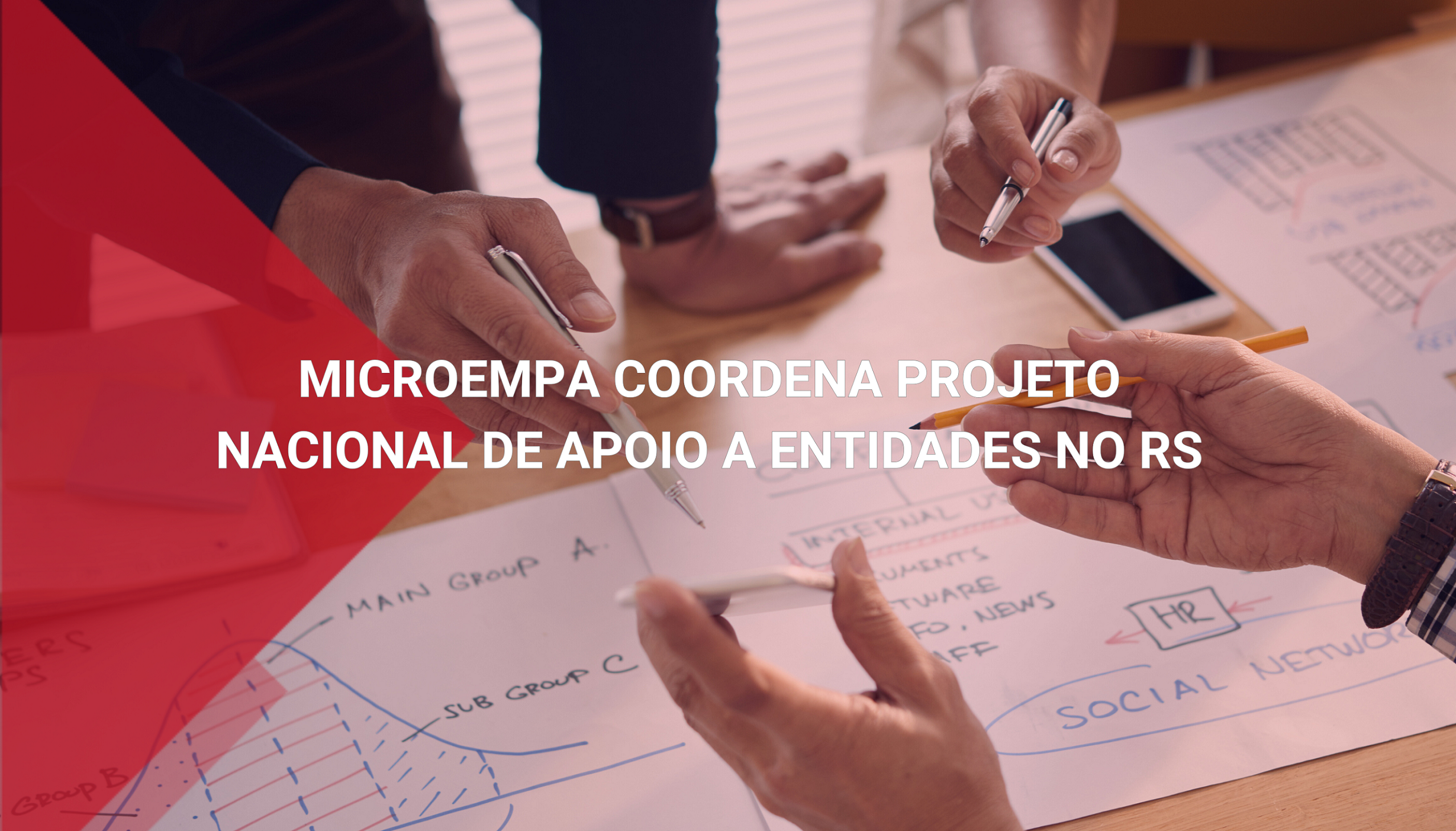 Na imagem podemos ver mãos de empresários que gesticulam e sinalizam pontos sobre um plano estratégico traçado em papel.